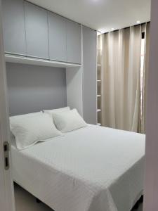 a bedroom with a white bed and a white cabinet at Cais Eco Residência in Ipojuca +25 photos
