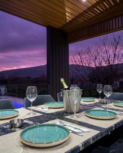 a table with plates and wine glasses on top of it at Luxury Villa Bar in Bar