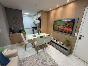 a dining room with a table and a tv on a wall at Recanto das Colinas II in Espirito Santo Do Pinhal