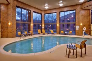 ein Pool in einer Hotellobby mit Stühlen und Tischen in der Unterkunft Courtyard by Marriott Ogden in Ogden
