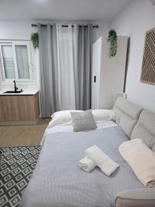 a bedroom with a large bed and a couch at Estudio Luminoso AM in Bollullos par del Condado