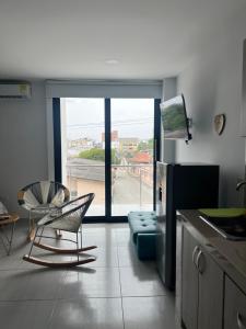 a kitchen with a chair and a couch and a window at Edificio Buenos Aires apartamento 304 moderno Sincelejo in Sincelejo