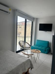 a bedroom with a blue couch and a chair at Edificio Buenos Aires apartamento 304 moderno Sincelejo in Sincelejo