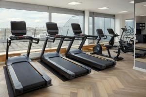 a gym with treadmills and elliptical machines at Courtyard by Marriott Pilsen in Pilsen