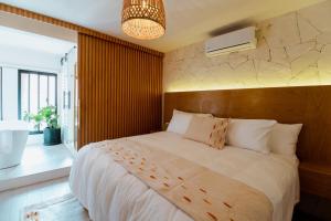 a bedroom with a large white bed and a fan at Bernardino Boutique Hotel in Guanajuato