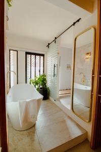 a bathroom with a tub and a large mirror at Bernardino Boutique Hotel in Guanajuato