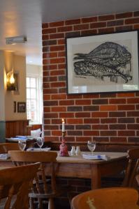 a brick wall in a restaurant with a candle on a table at The Dolphin Inn in Thorpeness