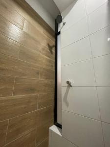a bathroom with a shower with wooden walls at Hostal Huella in Lambayeque