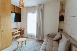 a living room with a couch and a desk at Bernardino Boutique Hotel in Guanajuato