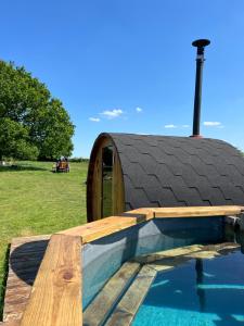a house with a pool and a roof at GreenFeilds Glamping Stargazing Yurts and Outdoor Spa in Milwich