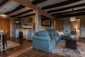 a living room with a blue couch and a kitchen at Villa Boljuncica in Boljun