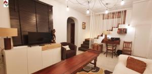 a living room with a couch and a tv on a wall at Casa con embarcadero in Los Mártires