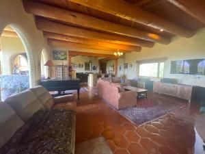 a large living room with couches and a piano at "Crows Nest" at Winsor Castle in Valdez