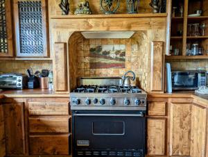 a kitchen with a stove with a tea kettle on it at "Crows Nest" at Winsor Castle in Valdez