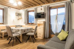 a living room with a table and chairs and a couch at Bauernhof Grussberggut GRATIS THERME & SOMMERBERGBAHN in Bad Hofgastein