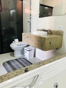 a bathroom with a toilet and a sink at Pousada Pinho Verde in Monte Verde +109 photos