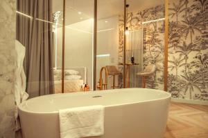 a white bath tub in a bathroom with a mirror at Gdańsk Luxury Stay Jacuzzi in Gdańsk