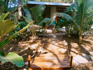 a wooden path in front of a house with palm trees at Isla Bonita in Cambutal