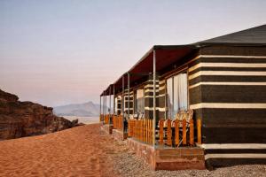 a house on the beach with chairs in front of it at Kinda Rum Luxury Camp in Wadi Rum