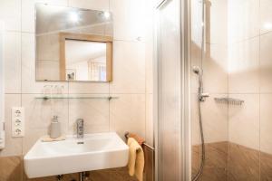 a white bathroom with a sink and a shower at Bauernhof Grussberggut GRATIS THERME & SOMMERBERGBAHN in Bad Hofgastein +42 photos