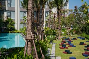 a resort with a pool and a yard with colorful obstacles at Lovely 2 Bdr Canvas BangTao in Laguna Phuket