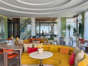 a living room with a yellow couch and colorful pillows at Lovely 2 Bdr Canvas BangTao in Laguna Phuket