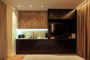 a kitchen with black cabinets and a microwave at Gdańsk Luxury Stay Jacuzzi in Gdańsk