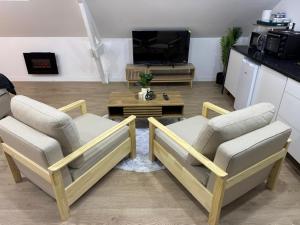 a living room with two chairs and a coffee table at Lilas House in Beauvais
