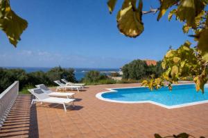 a patio with chairs and a swimming pool at Villa Aether Methoni in Methoni