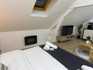 a white bedroom with a bed and a fireplace at Lilas House in Beauvais