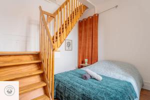 a bedroom with a bed and a wooden staircase at Cosy flat, Duplex, proche centre ville in Lens