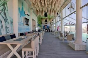a dining room with tables and chairs and windows at Arena Beach Resort & Spa in Hurghada