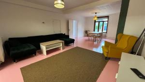 a living room with a black couch and yellow chairs at Grande Maison 17 personnes in Arras