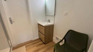 a small bathroom with a sink and a chair at Grande Maison 17 personnes in Arras