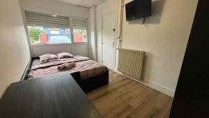 a small bedroom with a bed and a window at Grande Maison 17 personnes in Arras