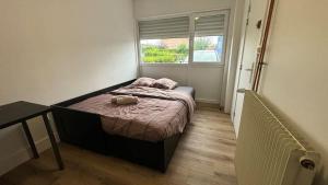 a small bedroom with a bed and a window at Grande Maison 17 personnes in Arras +65 photos