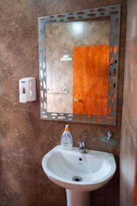 a bathroom with a sink and a mirror at Hostel Qiru Atacama in Sólor