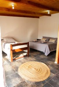 a room with two beds and a rug on the floor at Hostel Qiru Atacama in Sólor