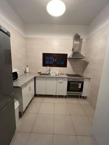 a kitchen with a sink and a stove top oven at Latin House in Funchal +1 photo