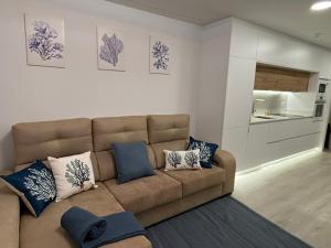 a living room with a brown couch and blue pillows at Marea in Sanxenxo
