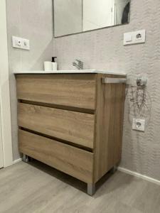 a bathroom with a wooden dresser with a mirror at Marea in Sanxenxo