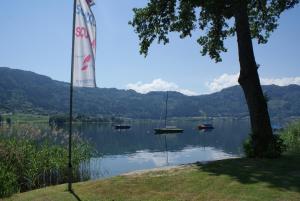 vistas a un lago con barcos en el agua en Pension AdlerHorst, en Steindorf am Ossiacher See