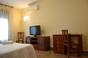 a bedroom with a bed and a television on a dresser at Ruralis Altozano in Montánchez