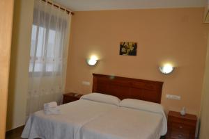 a bedroom with two beds with white sheets and a window at Ruralis Altozano in Montánchez +37 photos