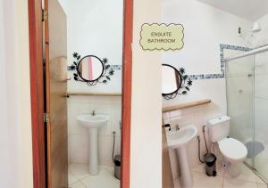 a bathroom with a sink and a toilet and two mirrors at Refúgio na Mata in Lençóis