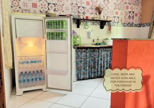 a kitchen with an open refrigerator with water bottles at Refúgio na Mata in Lençóis +7 photos