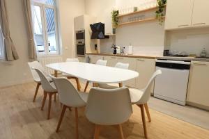 a white kitchen with a white table and chairs at L'As d'Aubert - 8 pers - Centre in Arras