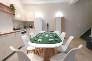 a white kitchen with a table and white chairs at L'As d'Aubert - 8 pers - Centre in Arras