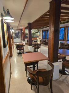 ein Restaurant mit Holztischen und -stühlen und Fenstern in der Unterkunft Campbell River Lodge in Campbell River