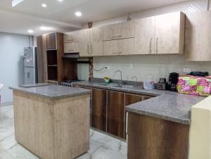 a kitchen with wooden cabinets and granite counter tops at Gabriela House in Ríohacha
